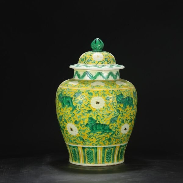 A large, covered jar with a carved pattern of flowers and lions in the imperial green glaze of the Ming Dynasty, from the old collection.