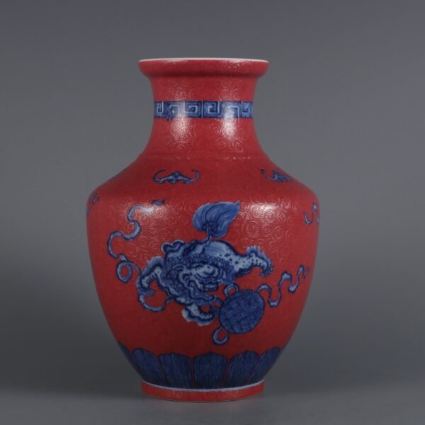 Qing Dynasty Qianlong period blue white lion rolling ball with rouge red ground carved flower vase
