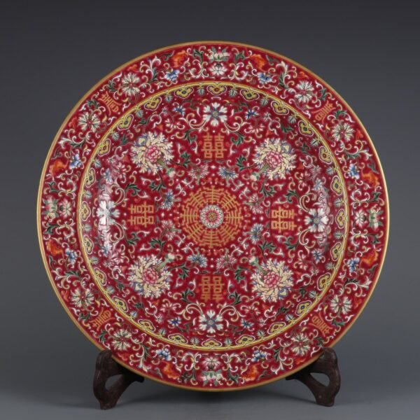 A large plate with a folded rim and rouge-red ground, enamel passionflower and gold-painted